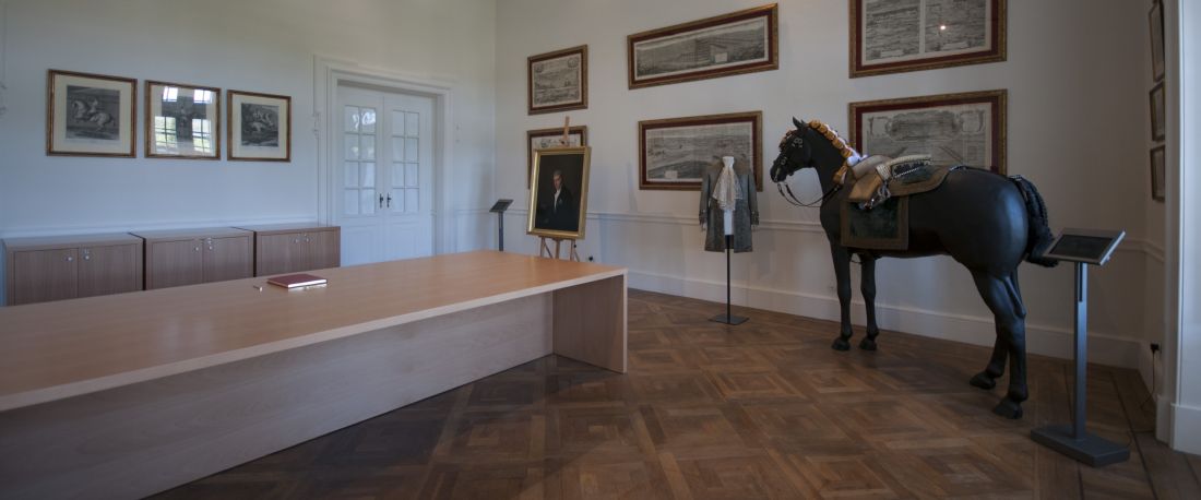Sala da Biblioteca de Arte Equestre com mesa de leitura e escultura de cavalo