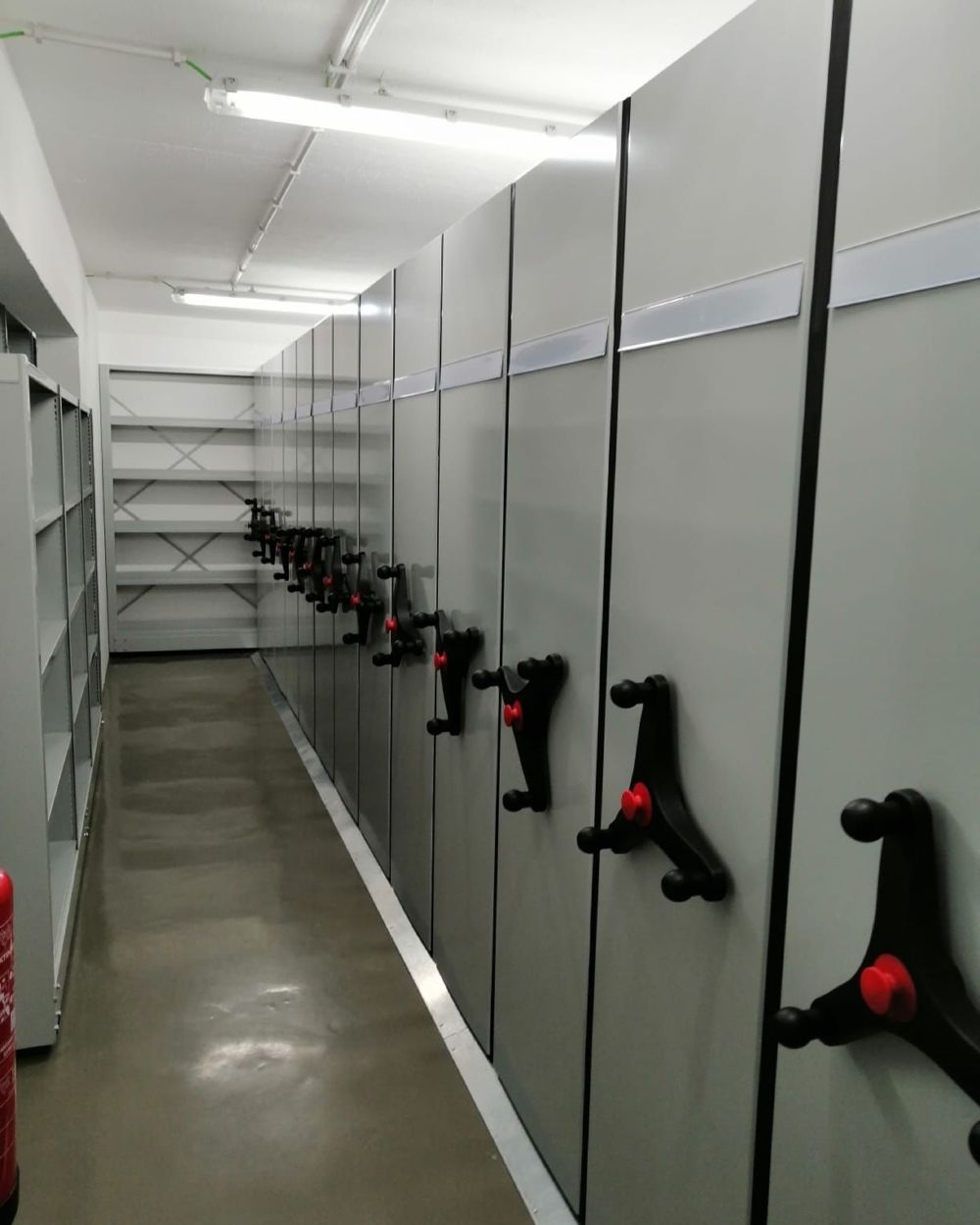 Fila de estantes compactas com manípulos no Arquivo Alto da Eira