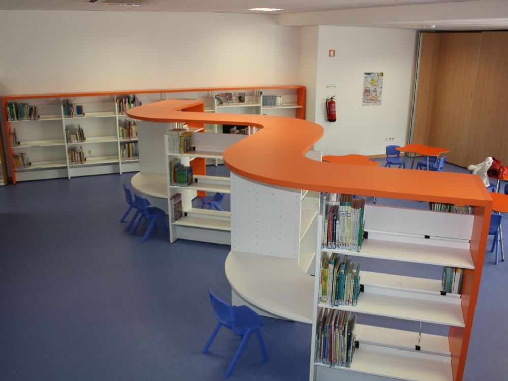 Estantes curvas com tampo laranja na zona infantil da Biblioteca Municipal da Lourinhã