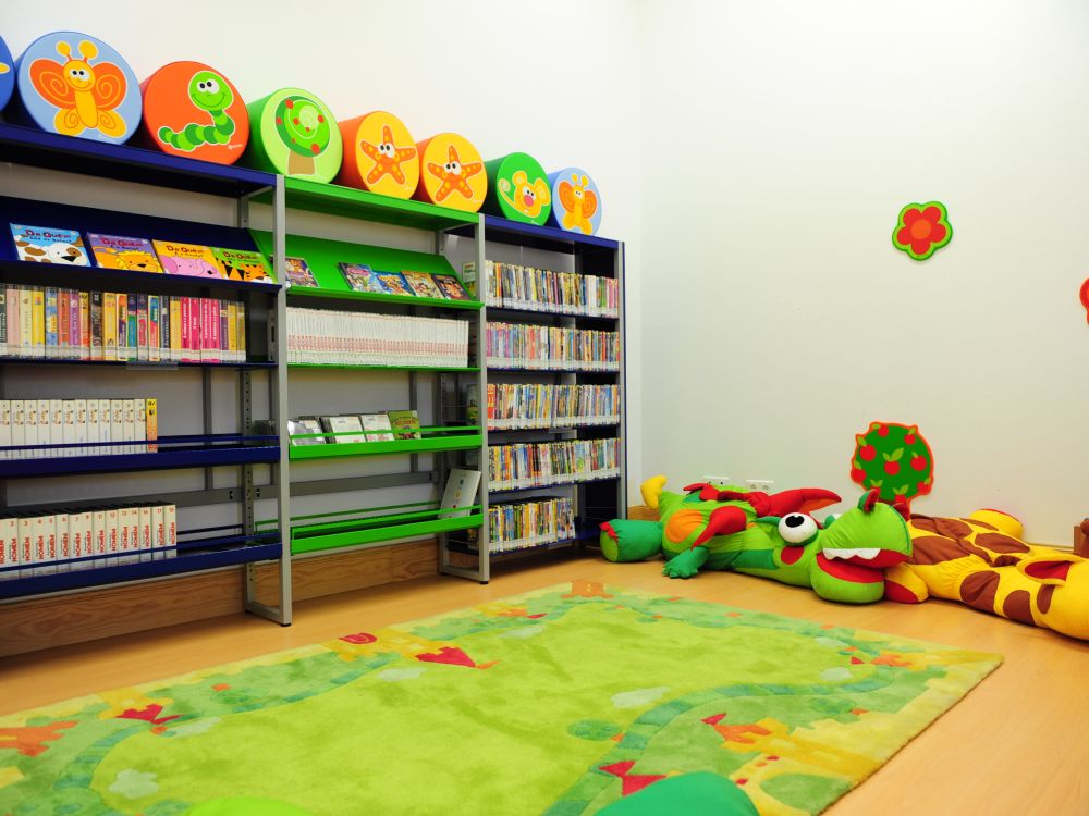 Zona infantil com estantes coloridas na Biblioteca Municipal de Mértola